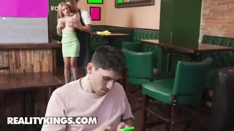 Der Freund schaut auf sein Handy und das Mädchen lässt sich vom Kellner begrapschen
