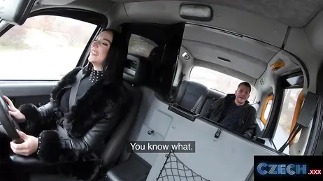 La bellissima tassista bruna continua a fissare il pene del cliente nello specchietto retrovisore.