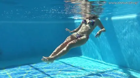 La vue d'une bombe en bikini string plongeant dans la piscine