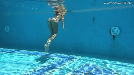 La vue d'une bombe en bikini string plongeant dans la piscine