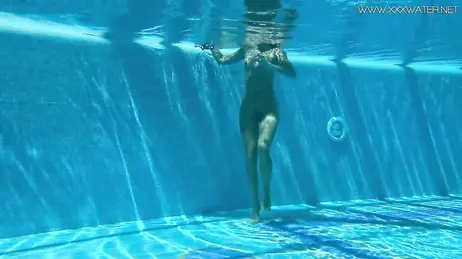 La vue d'une bombe en bikini string plongeant dans la piscine