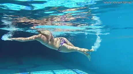 La vue d'une bombe en bikini string plongeant dans la piscine