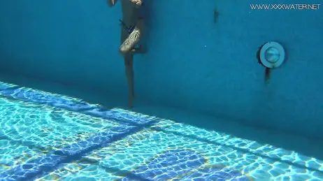 La vue d'une bombe en bikini string plongeant dans la piscine